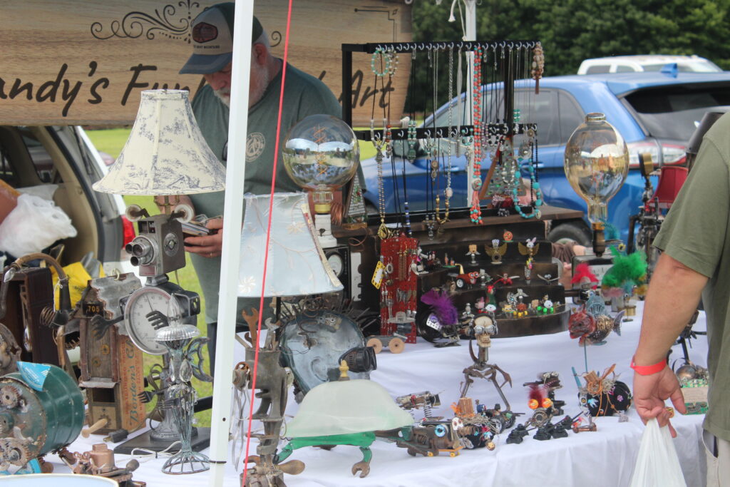 Crafted items made of various antiques sit upon a table for sale.